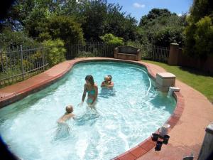 een groep mensen in een zwembad bij Cedarwood Guest House in Howick