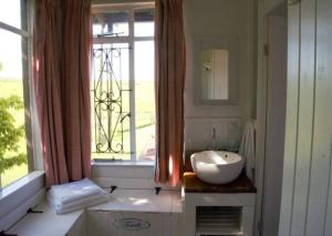 een badkamer met een wastafel en een raam bij Cedarwood Guest House in Howick +25 foto's