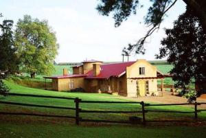 een groot huis met een hek ervoor bij Cedarwood Guest House in Howick