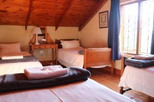 een slaapkamer met 2 bedden in een kamer met houten plafonds bij Cedarwood Guest House in Howick