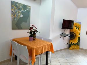 a dining room with a table with chairs and a painting at Villa Magnolia in Muravera