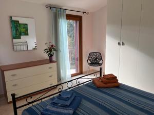 a bedroom with a bed and a dresser and a window at Villa Magnolia in Muravera