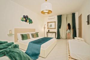 a woman standing in a bedroom with two beds at Beneduce B&B ROOMS in Santa Maria di Castellabate