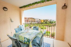 einen Balkon mit einem Tisch und Stühlen sowie einem großen Fenster in der Unterkunft LA SYMPHONIE, PISCINE, PLAGE in Gassin