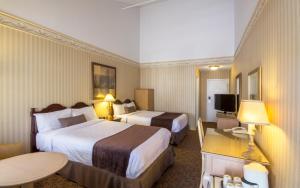 Auberge Québec tesisinde bir odada yatak veya yataklar