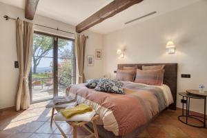 a bedroom with a large bed and a large window at Domaine des Chênes de la Galline in La Garde-Freinet