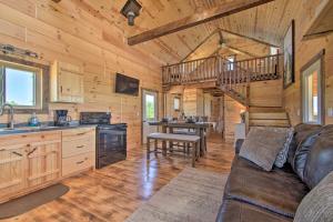 sala de estar con sofá y cocina en Peaceful Blanchardville Cabin on 35-Acre Farm, 