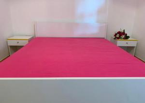 a bedroom with a pink bed with two tables at Gallipoli Mancaversa Futura Vacanza Andrea in Marina di Mancaversa