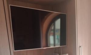 een flatscreen-tv zittend op een muur bij B&B Corte del Centro in Novate Milanese