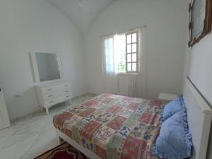 a bedroom with a bed and a dresser and a tv at Maison S+1 très bien équipée à 2mn de la plage in Kelibia