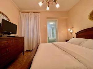 Un dormitorio con una cama y un televisor sobre una cómoda. en Casa di Maggio - by tourquoisevea, en Desenzano del Garda