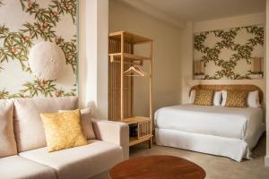 salon z łóżkiem i kanapą w obiekcie BYPILLOW Residence Abril w Sewilli