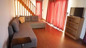 un salon avec un canapé et une télévision à écran plat dans l'établissement Karyada Hotel, à Çeşme