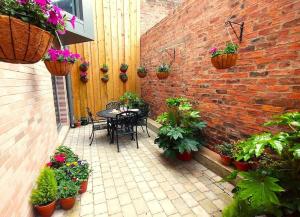 um pátio com uma mesa, cadeiras e vasos de plantas em The Boutique York Garden Studio em York