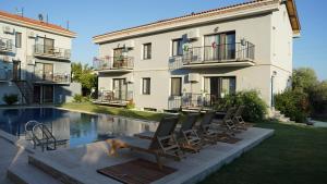- un bâtiment avec des chaises à côté de la piscine dans l'établissement Karyada Hotel, à Çeşme