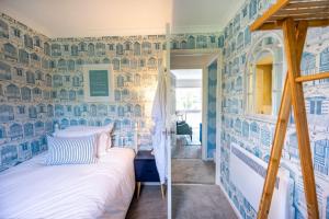 een slaapkamer met blauwe en witte muren en een bed bij Apartment 4, Hunstanton in Hunstanton