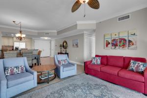 ein Wohnzimmer mit einem roten Sofa und 2 Stühlen in der Unterkunft Portofino Tower 3-1808 Stunning Beachfront National Seashore Views in Pensacola Beach