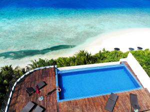 Ranthari Hotel and Spa Ukulhas Maldives في أوكولهاس: مسبح بجانب شاطئ المحيط