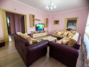 uma sala de estar com dois sofás e uma televisão em Cheerful 2 bedroom villa with free parking. em Gjirokastër