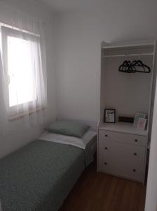 a bedroom with two beds and a window and a dresser at Apartment Petar - by the Sea in Gradac