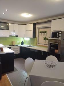a kitchen with white cabinets and a table and chairs at Apartment Petar - by the Sea in Gradac