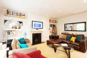 sala de estar con sofá y chimenea en Sunny 2 bedroom, 2 bathroom Apartment with Roof Terrace, en Londres