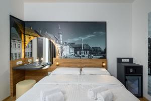 1 dormitorio con 1 cama blanca grande y un mural en la pared en B&B Hotel Maribor, en Maribor