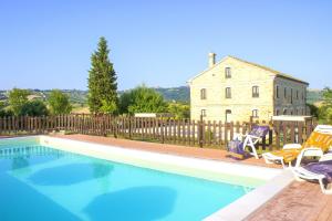 einen Pool mit zwei Stühlen und ein Haus in der Unterkunft 6 bedrooms villa with private pool enclosed garden and wifi at Montecarotto in Casa Vici