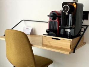 a desk with a chair and a coffee maker on it at BED Cauchy in Namur