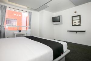 a white bedroom with a bed and a window at Hotel Euro Confort,Pachuca in Pachuca de Soto