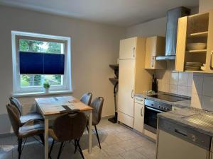 a kitchen with a table and chairs and a window at TOP LAGE 2 Zimmerwohnung mit Balkon und bester Aussicht in OG 2 links in Rostock