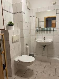 uma casa de banho com um WC e um lavatório em TOP LAGE 2 Zimmerwohnung mit Balkon und bester Aussicht in OG 2 links em Rostock