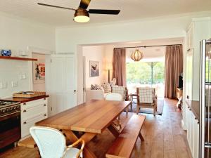 a kitchen and dining room with a wooden table and chairs at Milkwood Cottage, Beachfront family vacation home, Sleeps 6 in Gordonʼs Bay +24 photos