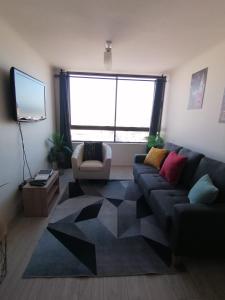 ein Wohnzimmer mit Couch und großem Fenster in der Unterkunft AMUNATEGUI 173 Iquique Centro, ejecutivos in Iquique