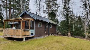 eine kleine Holzhütte in der Mitte eines Feldes in der Unterkunft Fritidshus Rostockvägen 40B - Guest House - Bring own bed sheets in Norrtälje