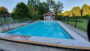 a swimming pool with a gazebo and a house at Fritidshus Rostockvägen 40B - Guest House - Bring own bed sheets in Norrtälje