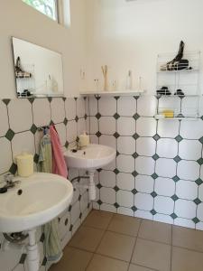 a bathroom with two sinks and a mirror at Rezi-dencia Gyógynövényfalu in Rezi