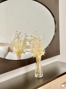 um vaso de flores sobre uma mesa em frente a um espelho em Apartment Orik em Orikum