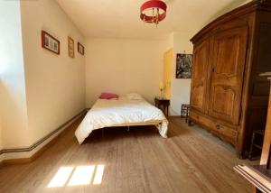 1 dormitorio con 1 cama y un gran armario de madera en Maison de 4 chambres avec jardin amenage et wifi a Bagnac sur Cele, en Linac