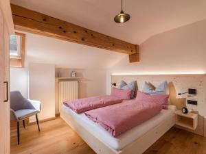 a bedroom with a large bed with pink pillows at Lainthalerhof in Oberaudorf