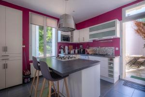 une cuisine avec des murs violets et un comptoir noir dans l'établissement Maison de la Gaîté, à Amboise