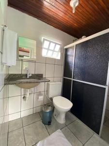 e bagno con servizi igienici, lavandino e doccia. di Pousada Tapuia a Porto Seguro