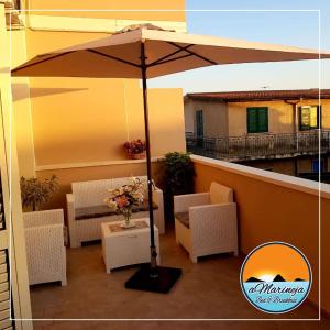un ombrellone su un balcone con tavoli e sedie di B&B aMarineja a Nicotera Marina