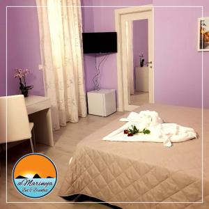 Un dormitorio con paredes moradas y una cama con flores. en B&B aMarineja en Nicotera Marina
