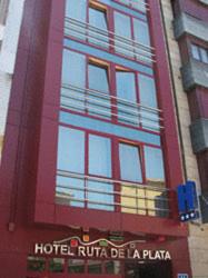 a red building with a balcony on the side of it at Hotel Ruta de la Plata de Asturias in Pola de Lena