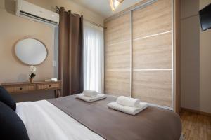 een slaapkamer met een bed met twee handdoeken erop bij Le Centre Ville in Athene
