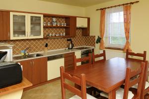 a kitchen with a wooden table and a dining room at PETR-A in Frymburk