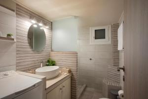 een witte badkamer met een wastafel en een spiegel bij Le Centre Ville in Athene +13 foto's