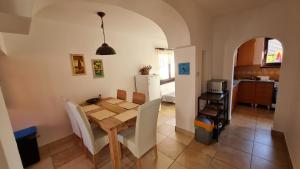 a kitchen and dining room with a wooden table and chairs at Domček u Babky in Liptovský Mikuláš