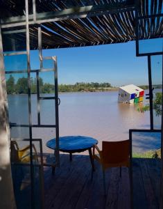 a deck with a table and chairs in the water at La Wayaba in Hernandarias